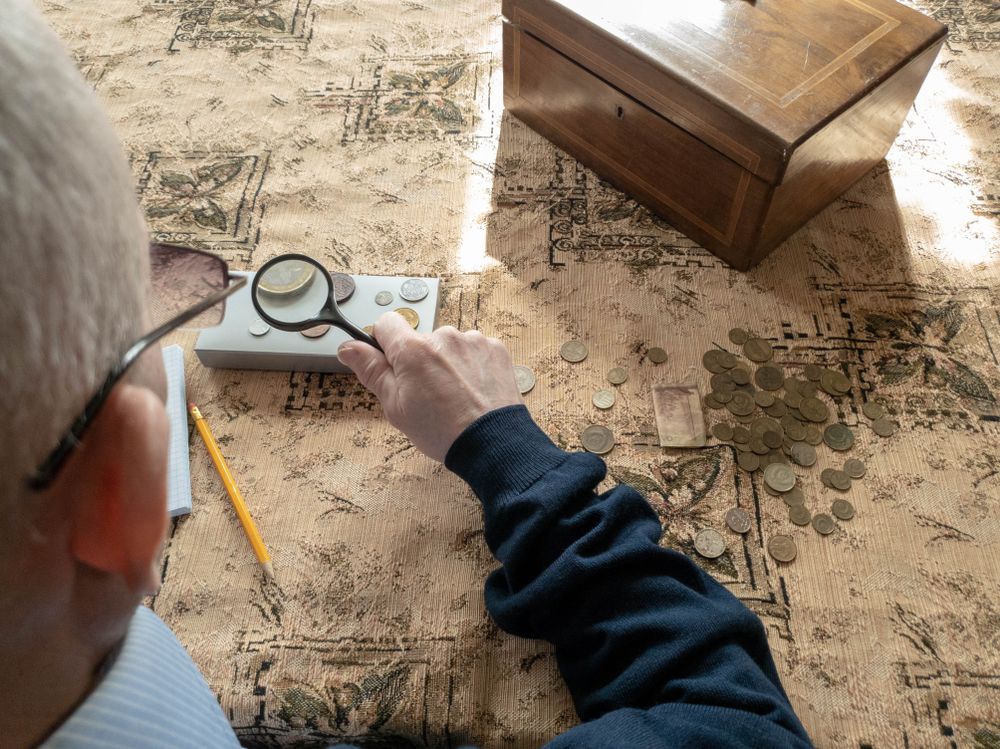 The Coin Evaluator. The collector of coins. The man considers ancient coins.